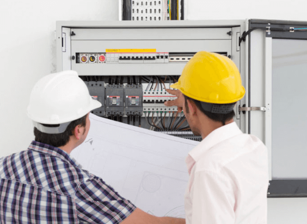 Hombre ayudando a otro en una caseta de electricidad